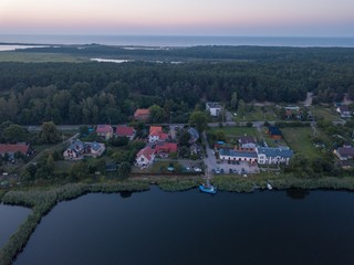 Obraz premium Beautiful sunset over estuary of Vistula river in Gdansk. Summer sunset over sea and river and small village.