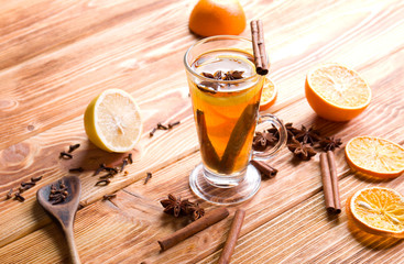 Hot Christmas tea with spices on wood.