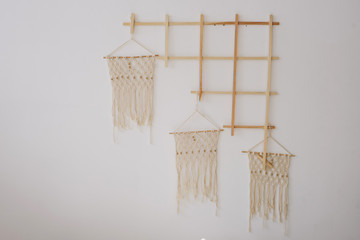 Big macrame on a white brick wall. place for text