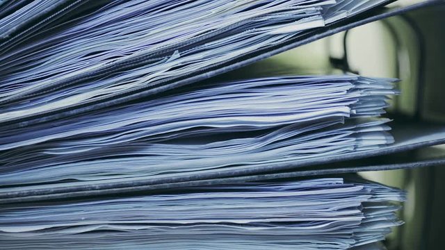 Office paperwork or documents in archive folders, stacked on top of each other. Vertical dolly footage.