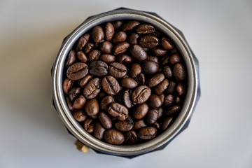 Coffee beans in mocha pot centered high angle, wide crop