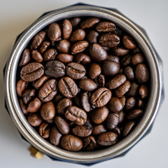 Coffee beans in mocha pot centered high angle, tight crop