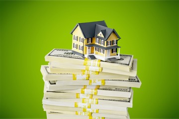 Stack of money with house on background