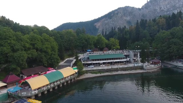Aerial view of a sailboat on alpine lake Ritsa. Parking of catamarans against, catamarans stand on water, parking of catamarans in water near shore.
