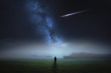 Obraz na płótnie Canvas Dreamy surreal landscape with starry night sky and man silhouette