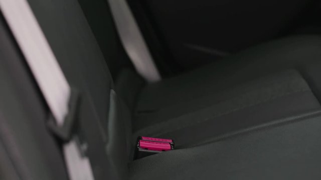 Closeup footage of the back seat of a car, focus on the safety belt locks.