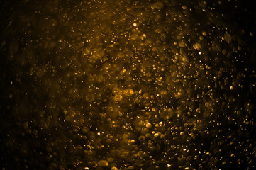 Light and flare in golden tones bokeh abstract background with copy space.