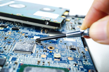 Technician repairing inside of hard disk by soldering iron. Integrated Circuit. the concept of data, hardware, technician and technology.