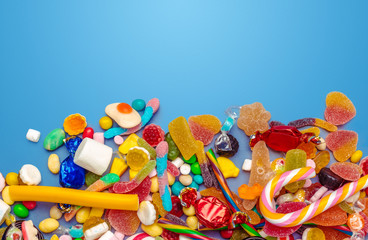 Colorful candies on table on blue background