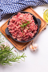 Raw minced meat in bowl  with ingredients for cooking