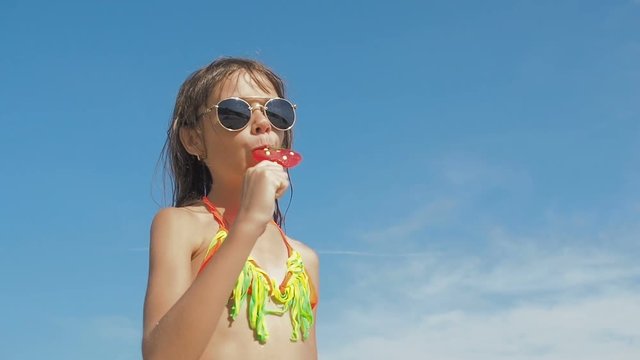 Child on the beach with a candy.