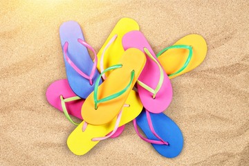 Fototapeta na wymiar Pairs Of Flip-flops On Beach, vacation concept