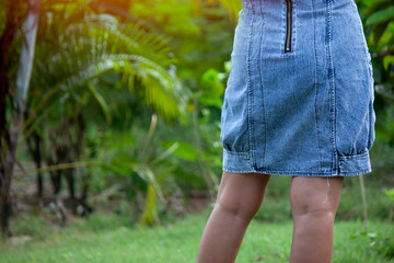 Women wearing jean skirts standing in the garden.