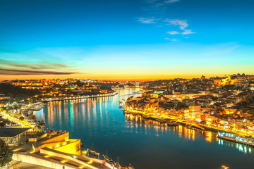 Oporto cityscape reflecting on Douro River at twilight. Porto is the second Portugal's largest city. Picturesque urban evening cityscape.