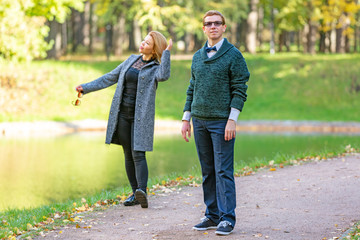 Obraz premium Couple talking seriously outdoors in a park with a green background