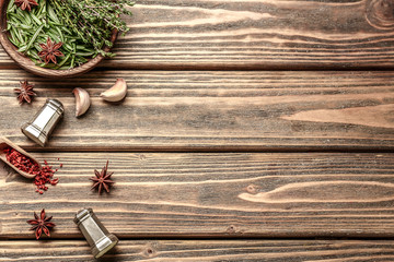 Fresh aromatic herbs with spices on wooden background