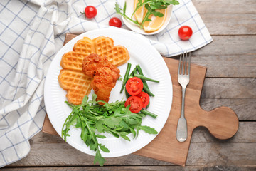Heart shaped waffles with chicken and vegetables on plate