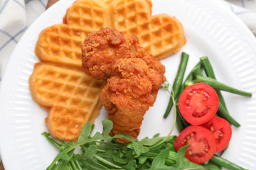 Heart shaped waffles with chicken and vegetables on plate, closeup