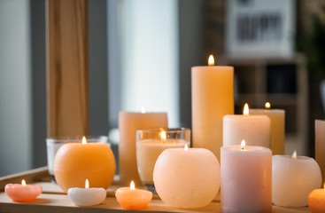 Fototapeta na wymiar Beautiful burning candles on wooden table indoors