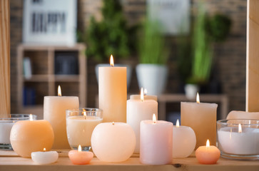 Fototapeta na wymiar Beautiful burning candles on wooden table indoors