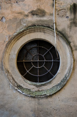 Old round shaped window in the streets of Rome.