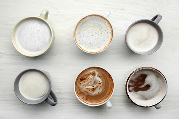 Many cups with tasty aromatic coffee on white table