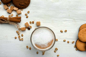 Glass of tasty aromatic coffee with cookies on white table