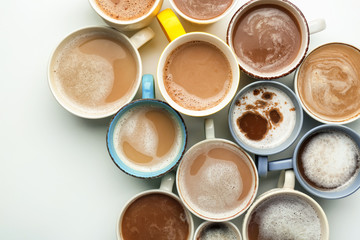 Many cups with tasty aromatic coffee on white background, top view