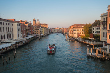 Venice , Italy - October 17 2018: Sailing on a wooden boat through venice on a bright day with a clear blue sky.