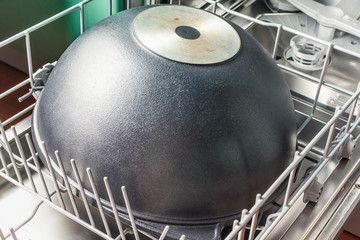 Large black cauldron lies in the lower compartment of the dishwasher