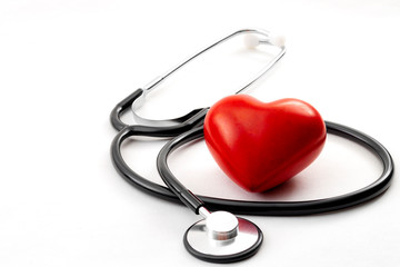 Yearly health check up, disease diagnosis medicine, healthcare and cardiology concept with a red heart and a stethoscope isolated on a hospital white background