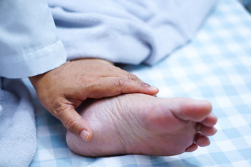 Doctor touching foot of Asian senior or elderly old lady woman patient with love, care, helping, encourage and empathy at nursing hospital ward : healthy strong medical concept 