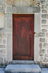 Fototapeta na wymiar Old wooden door, arched stone wall.Rustic and retro style.