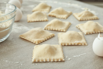 Tasty raw ravioli on table