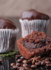 Mafine with chocolate and chocolate glaze. Served with coffee beans and thyme. On a black tile