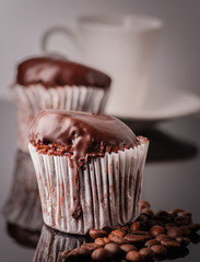 Mafine with chocolate and chocolate glaze. Served with coffee beans and thyme. On a black tile
