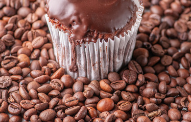 Mafine with chocolate and chocolate glaze. Served with coffee beans and thyme. On a black tile