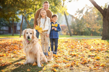Happy family with dog in autumn park