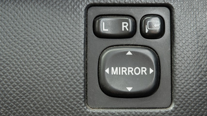 Side mirror direction control functions button inside interior passenger cabin. close-up view