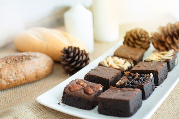 Brownie chocolate cake on white plate, with Christmas decoration background,.selective focus