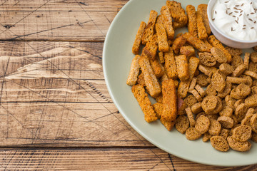 Croutons of grain bread with spices in the dishes. Wooden background. Copy space