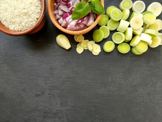 Ingredients on black background,rice,chopped onion,leek,garlic