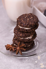 Brown biscuits close-up. Cookies with nuts on a bright table with nuts, cinnamon, milk