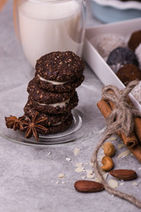 Brown biscuits close-up. Cookies with nuts on a bright table with nuts, cinnamon, milk