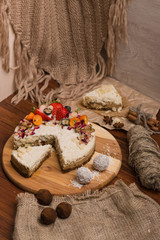 Cake with berries and fruits on a wooden table. Candy, nuts, cinnamon on a burlap.