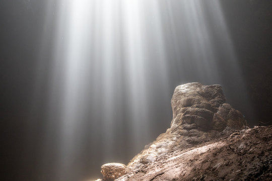 Light rays shining on a rock inside cave Goa Jomblang in East Java, Indonesia