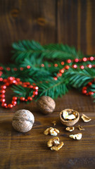 Christmas background, walnuts, shell, fir tree branch and red bead balls Christmas decoration in shape of a heart on rustic wooden table. Empty space for text, New Year theme concept.