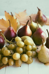 Autumn concept. Autumn maple leaves and fresh pears on a wooden table. Vintage style.