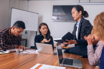 Businesswoman suffering migraines at job working on line with a laptop sitting in a desktop at office. Tired businesswoman suffering of headache. 