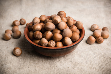 Hazelnuts in a bowl of glazed earthenware on a linen cloth